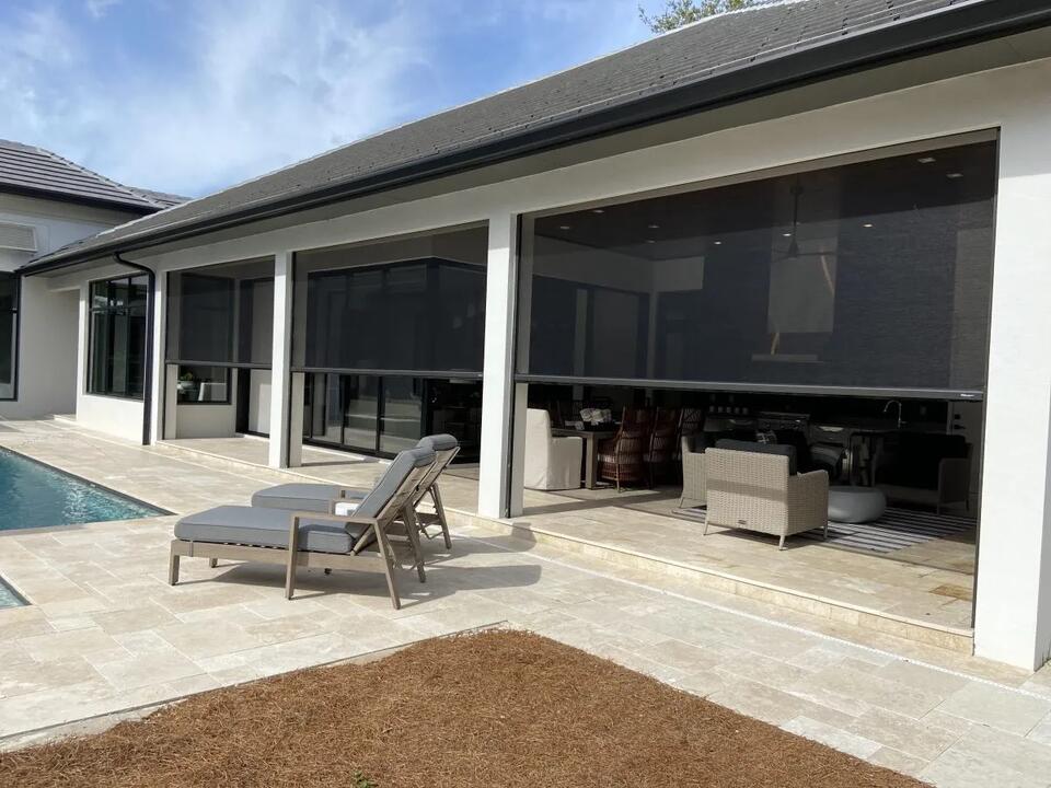 Modern outdoor seating area featuring retractable patio screens that provide shade, privacy, and protection from the elements.